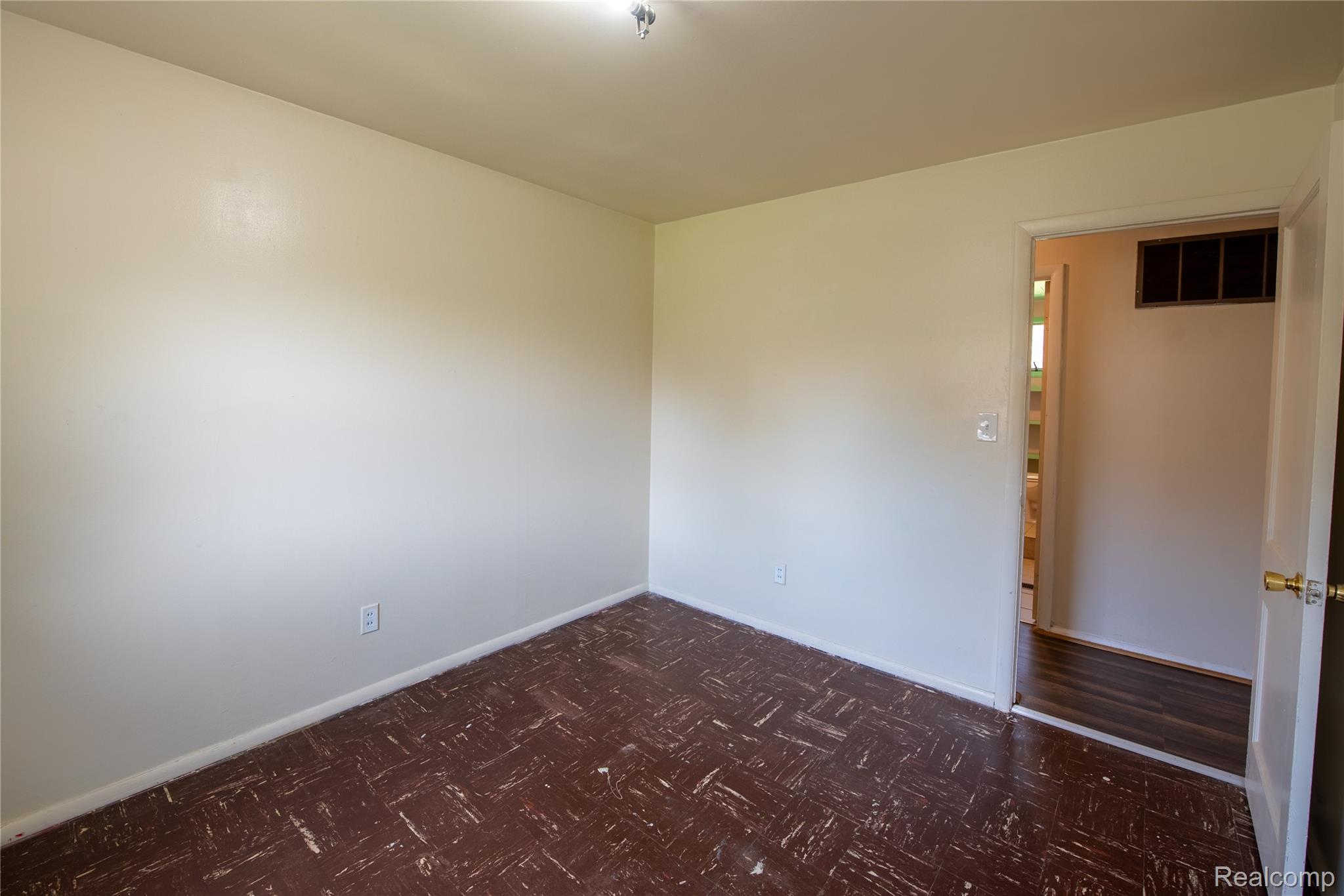 1190 Meadow Road Tawas City, MI 48763 - Photo 23 of 26 Spare room featuring baseboards and dark floors