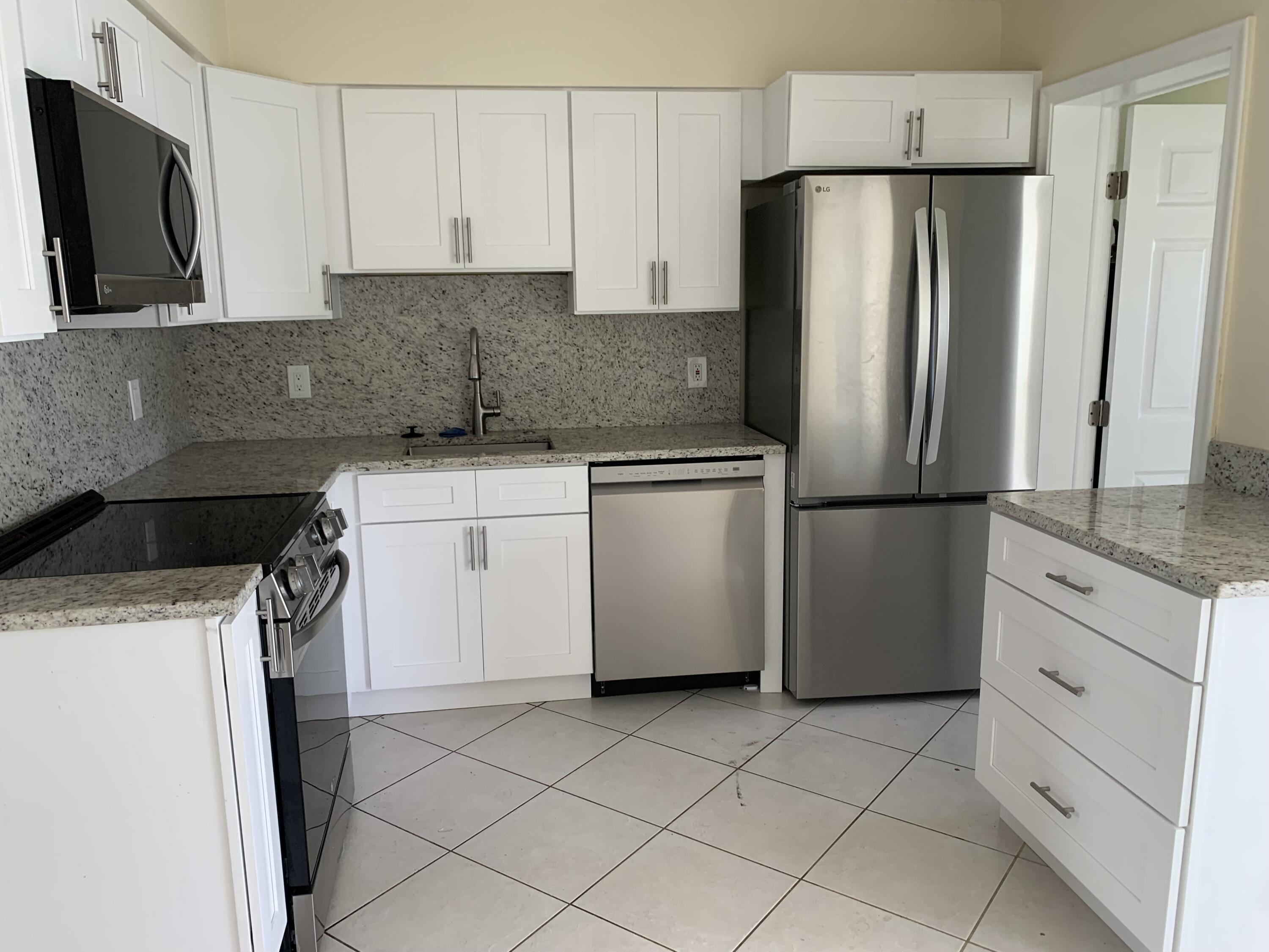 2802 Regency Court Delray Beach, FL 33445 - Photo 4 of 10 a kitchen with appliances a sink and cabinets