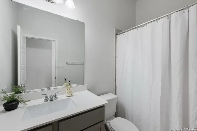 a bathroom with a sink vanity mirror and toilet