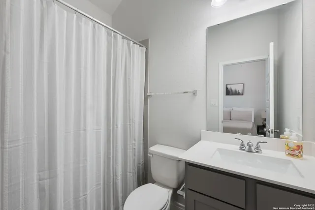 a bathroom with a sink vanity mirror and toilet