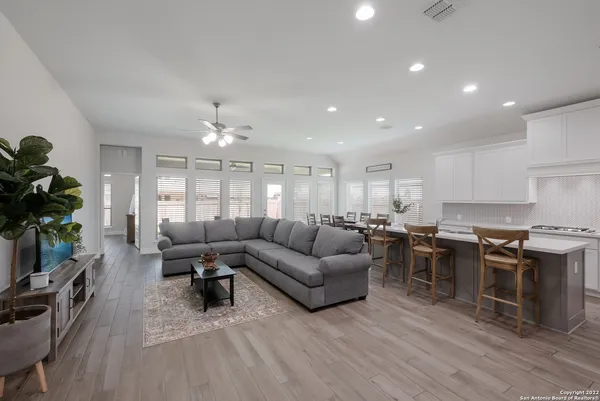 a living room with lots of furniture and kitchen view