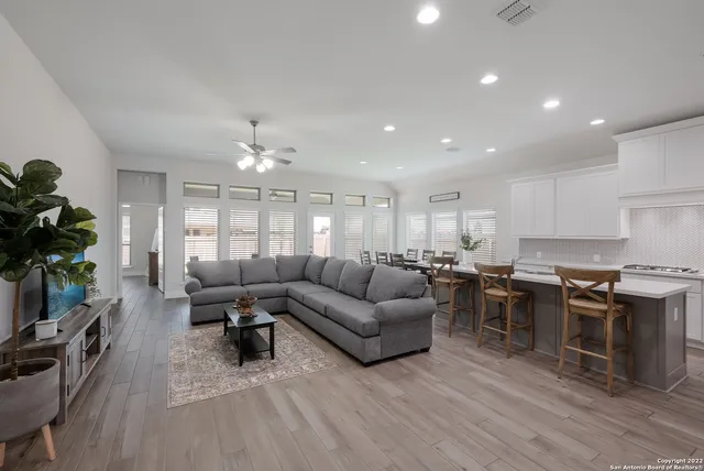 a living room with lots of furniture and kitchen view