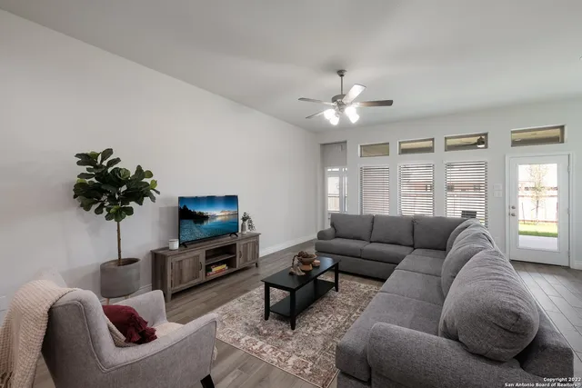 a living room with furniture a chandelier a window and a flat screen tv