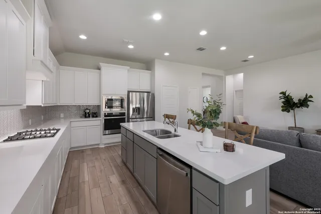 a kitchen with granite countertop kitchen island white cabinets and stainless steel appliances