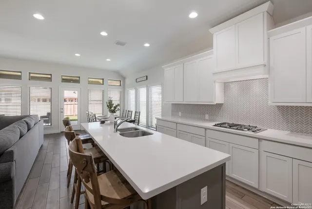 a kitchen with white cabinets stove and refrigerator
