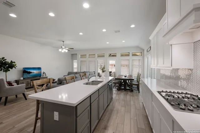 a kitchen with sink stove and chairs