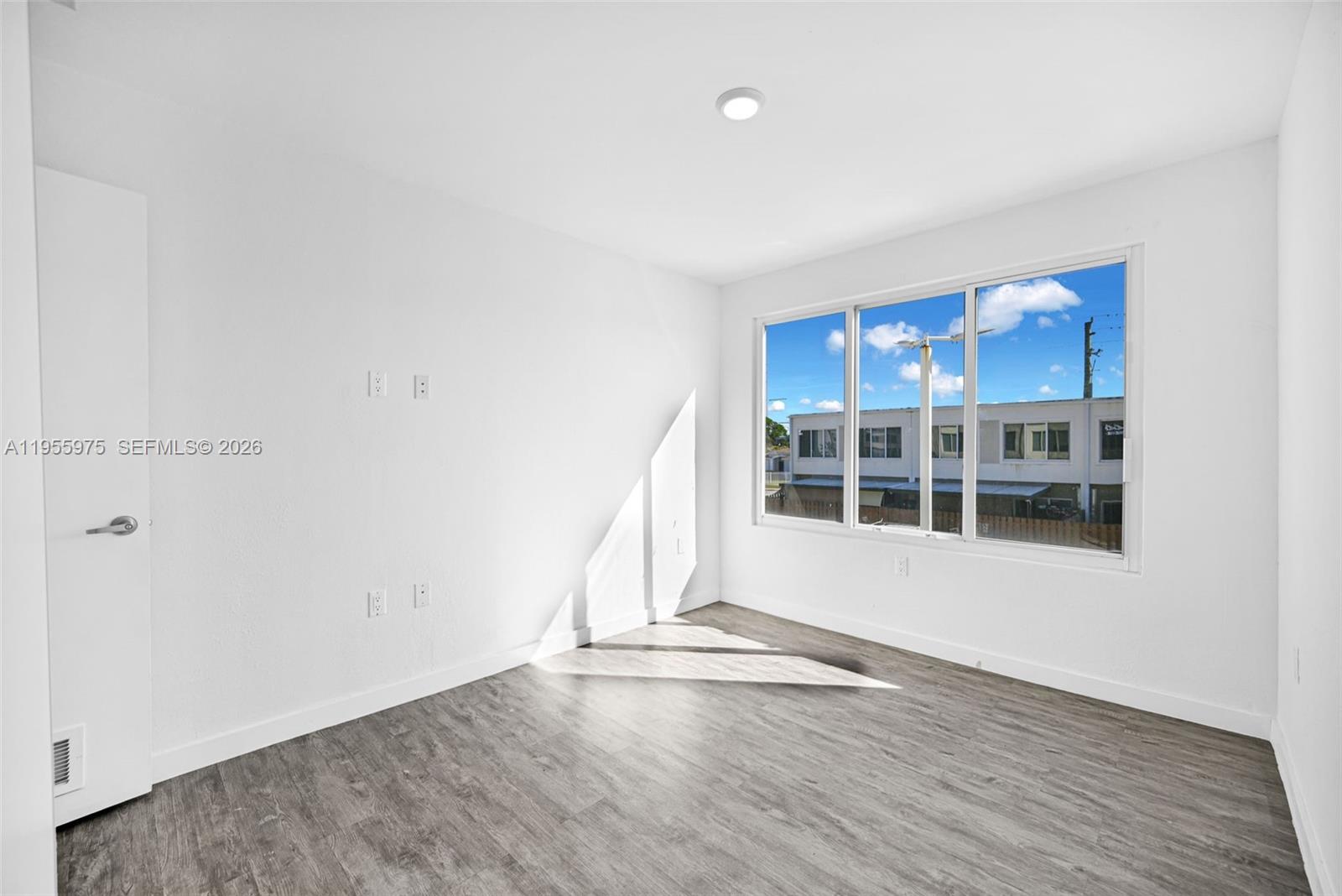 25874 Southwest 139th Court Homestead, FL 33033 - Photo 22 of 56 an empty room with wooden floor and windows