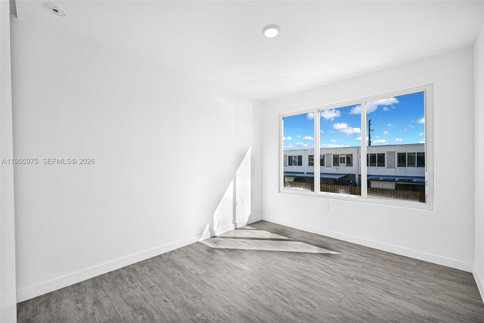 25874 Southwest 139th Court Homestead, FL 33033 - Photo 38 of 56 an empty room with wooden floor and windows