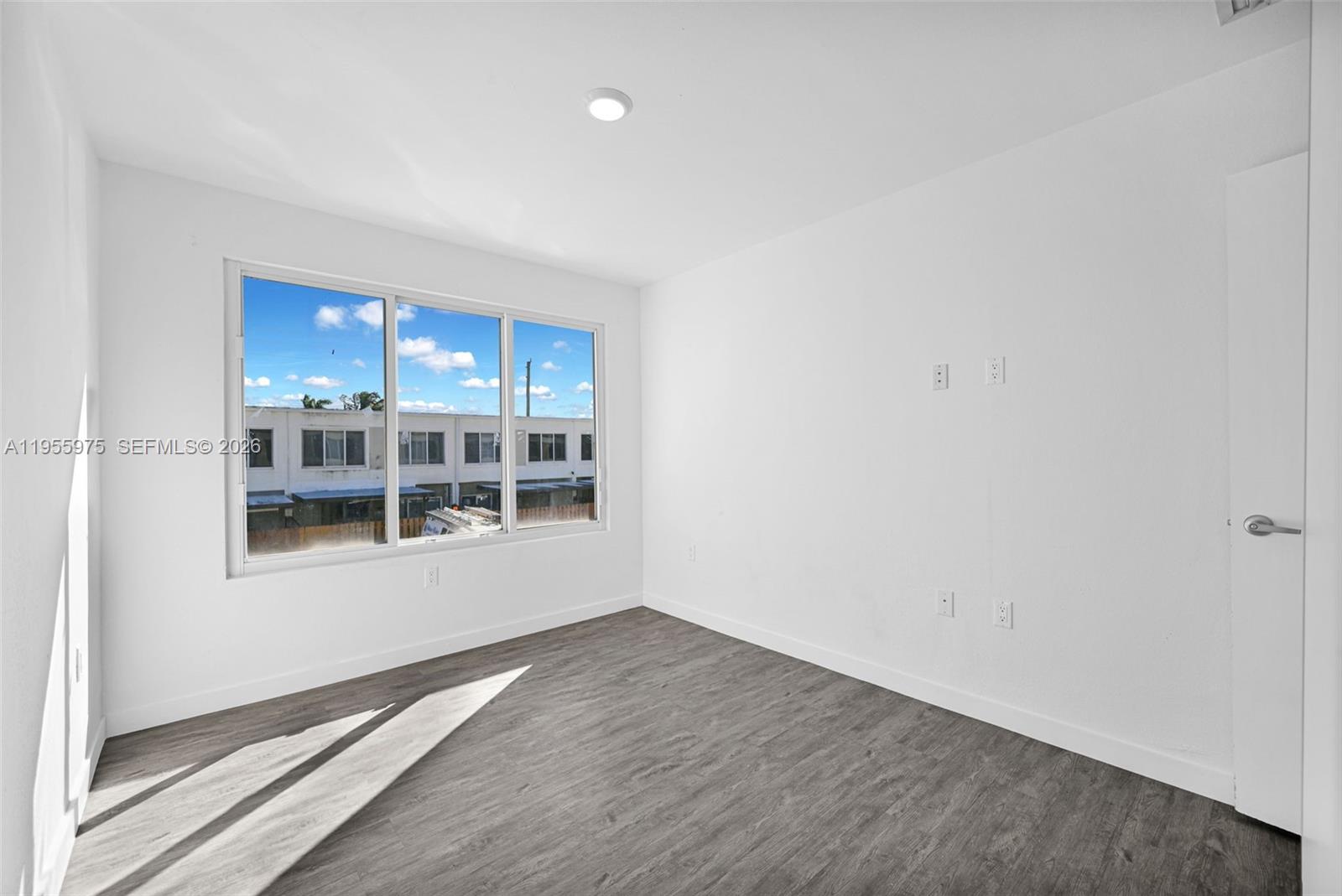 25874 Southwest 139th Court Homestead, FL 33033 - Photo 41 of 56 an empty room with wooden floor and windows