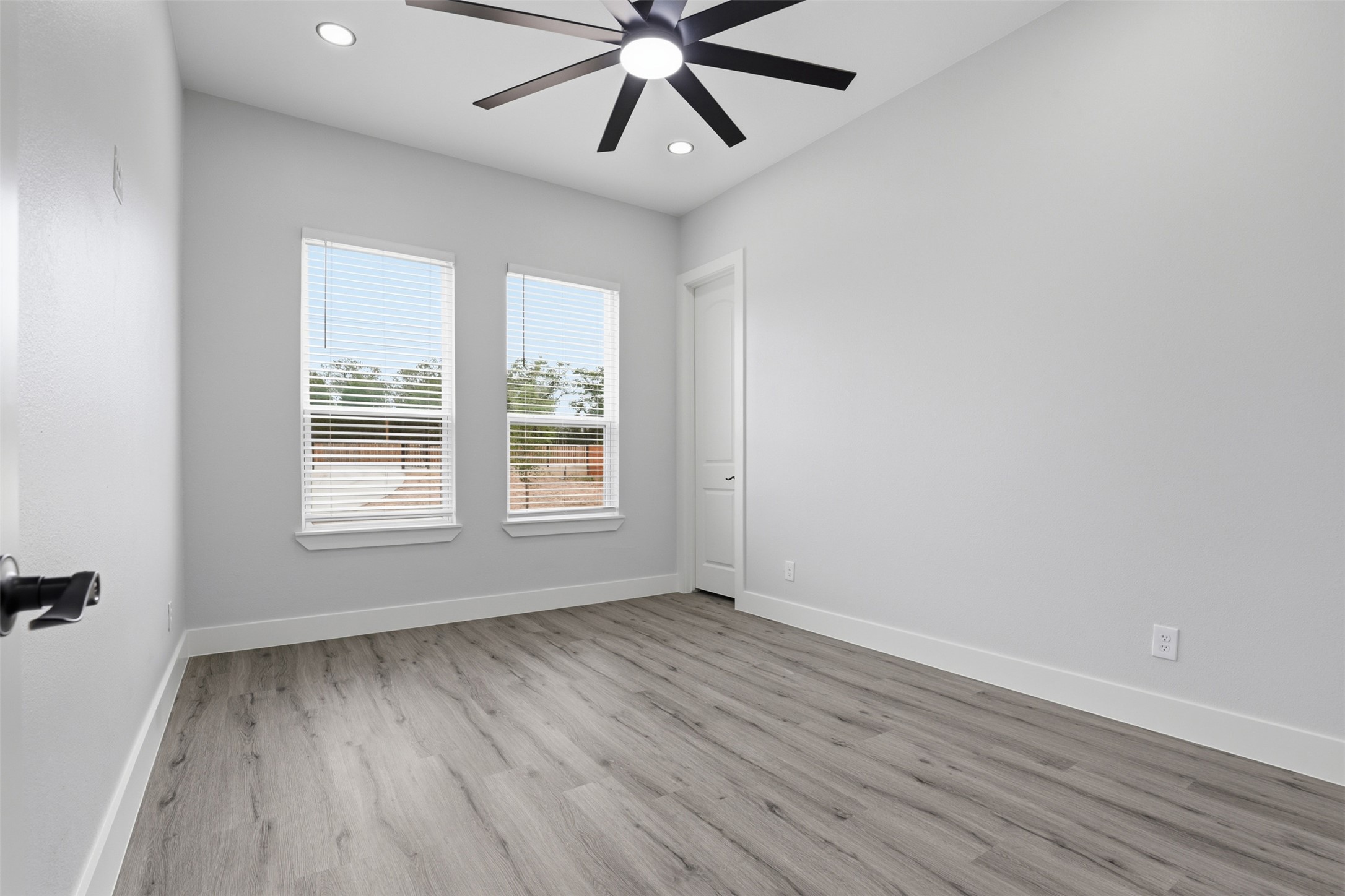 113 Los Robles Road Elgin, TX 78621 - Photo 13 of 20 Spacious interior room featuring wood-finish flooring, two windows with blinds, recessed ceiling lights, and a modern ceiling fan