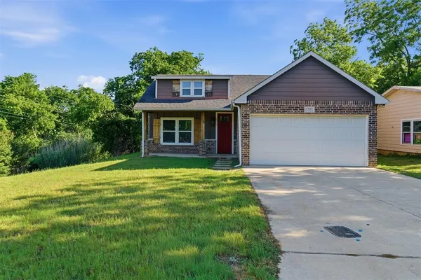 a front view of a house with a yard and garage