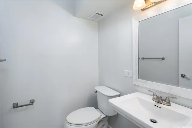 a bathroom with a sink mirror and toilet