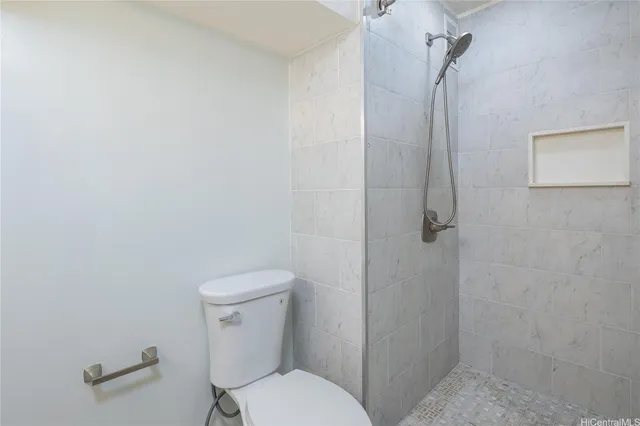 a white toilet sitting next to a shower