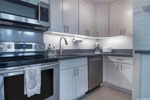a kitchen with granite countertop cabinets stainless steel appliances and sink