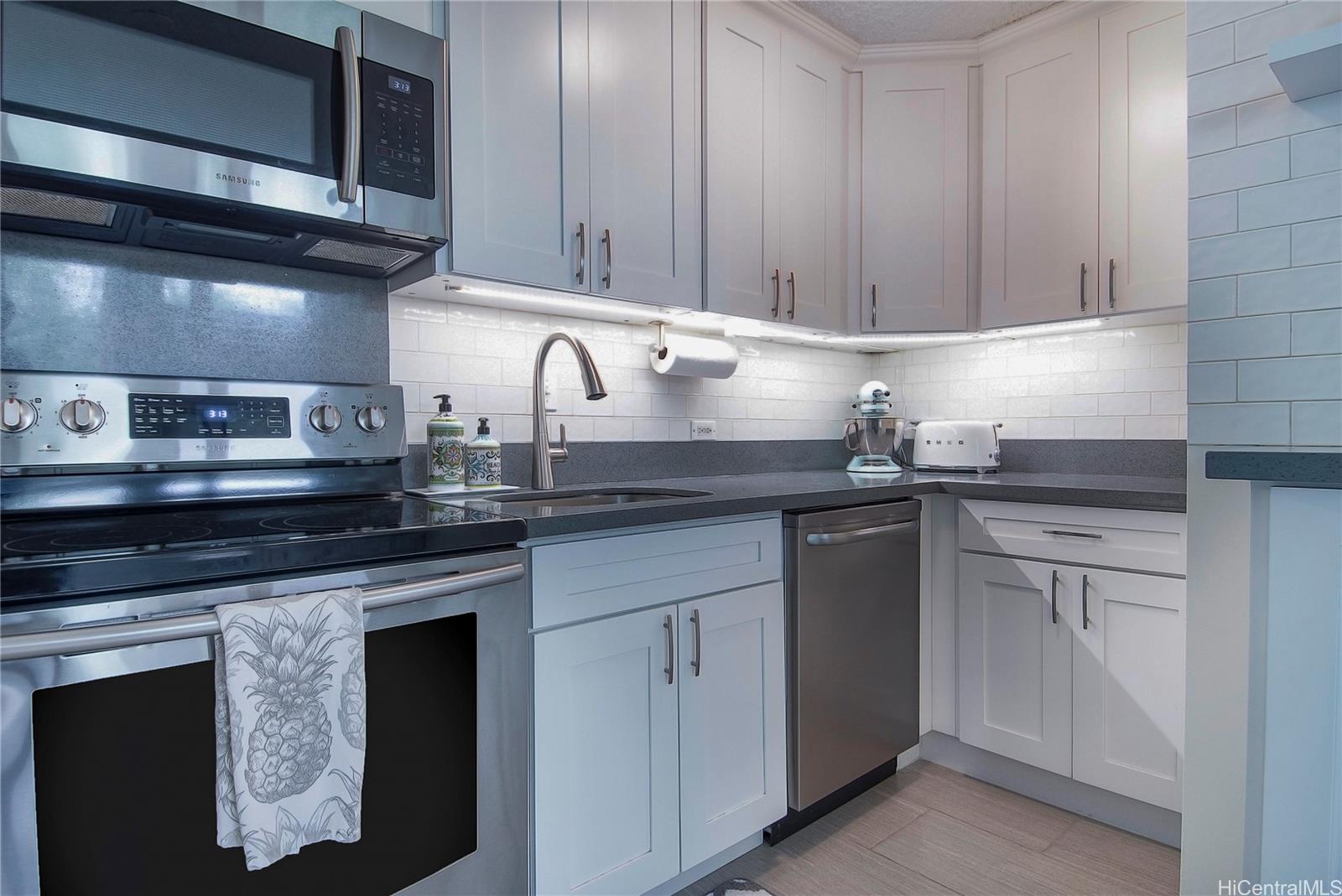 3103 Pualei Circle, Unit 204 Honolulu, HI 96815 - Photo 3 of 17 a kitchen with granite countertop cabinets stainless steel appliances and sink