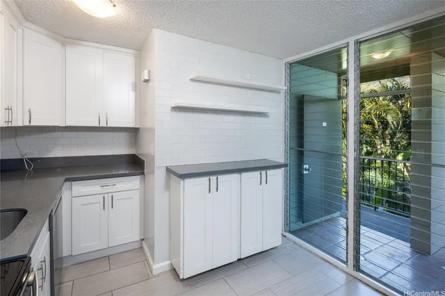 a kitchen with white cabinets and a potted plant