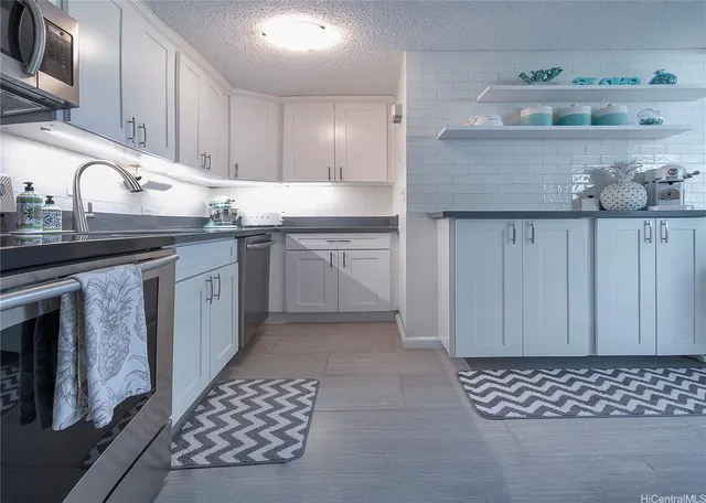 a kitchen with stainless steel appliances granite countertop a sink stove and cabinets