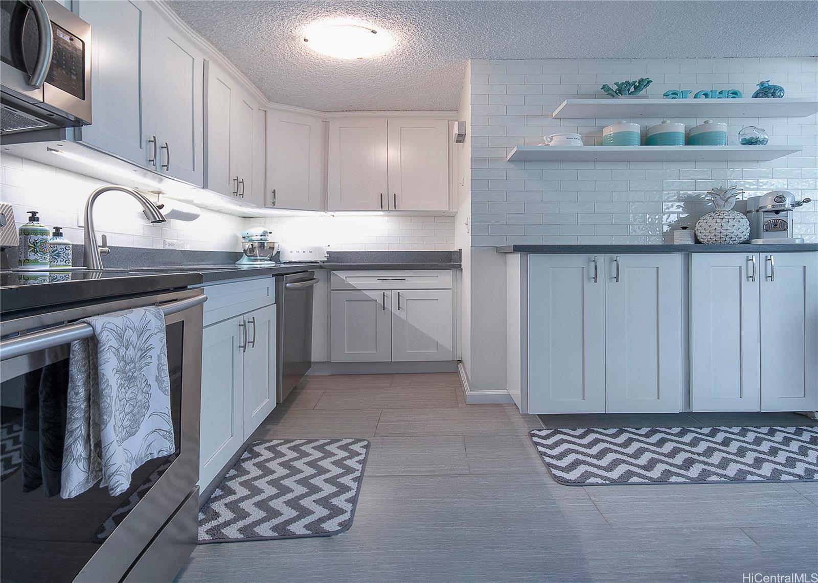 3103 Pualei Circle, Unit 204 Honolulu, HI 96815 - Photo 5 of 17 a kitchen with stainless steel appliances granite countertop a sink stove and cabinets