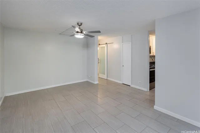 an empty room with closet and a ceiling fan