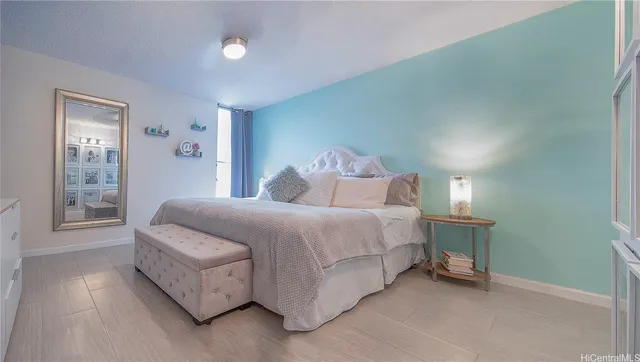 a spacious bedroom with a bed and a lamp