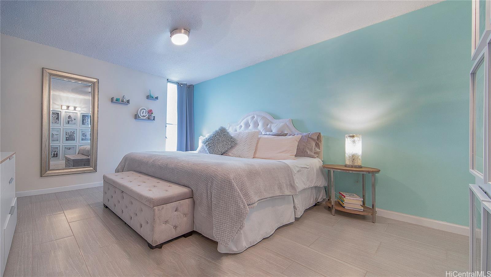 3103 Pualei Circle, Unit 204 Honolulu, HI 96815 - Photo 9 of 17 a spacious bedroom with a bed and a lamp