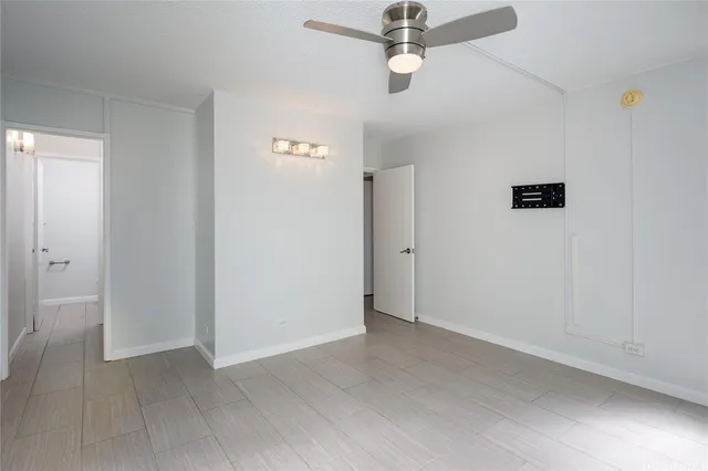 an empty room with a ceiling fan and carpet