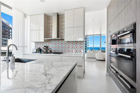 a kitchen with granite countertop a sink a counter top space appliances and cabinets