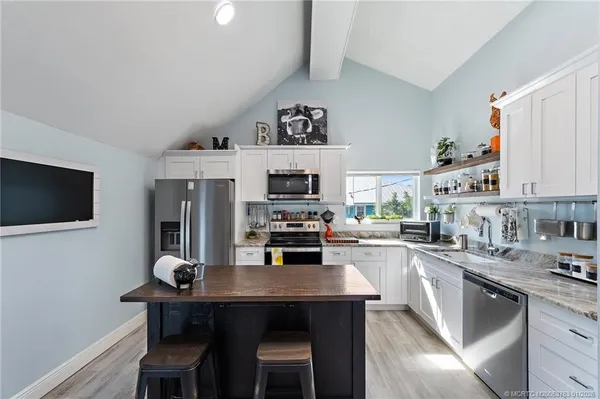 a kitchen with stainless steel appliances granite countertop a sink stove and cabinets