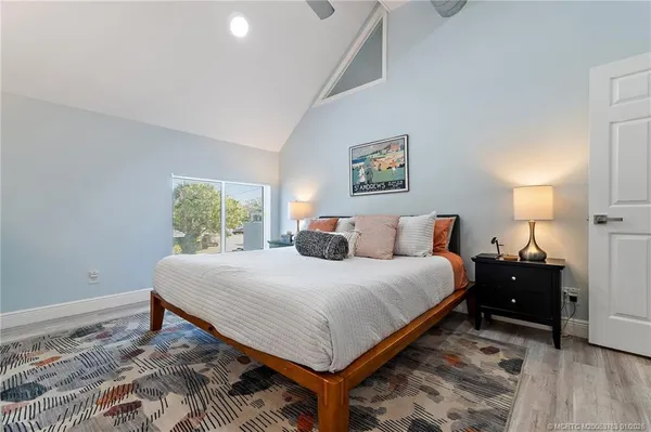 a bedroom with bed and wooden floor
