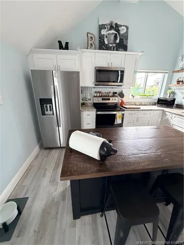 a kitchen with a wooden floor and a fireplace