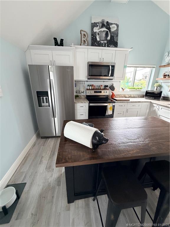 310 Southeast Denver Avenue, Unit 2 Stuart, FL 34994 - Photo 4 of 8 a kitchen with a wooden floor and a fireplace