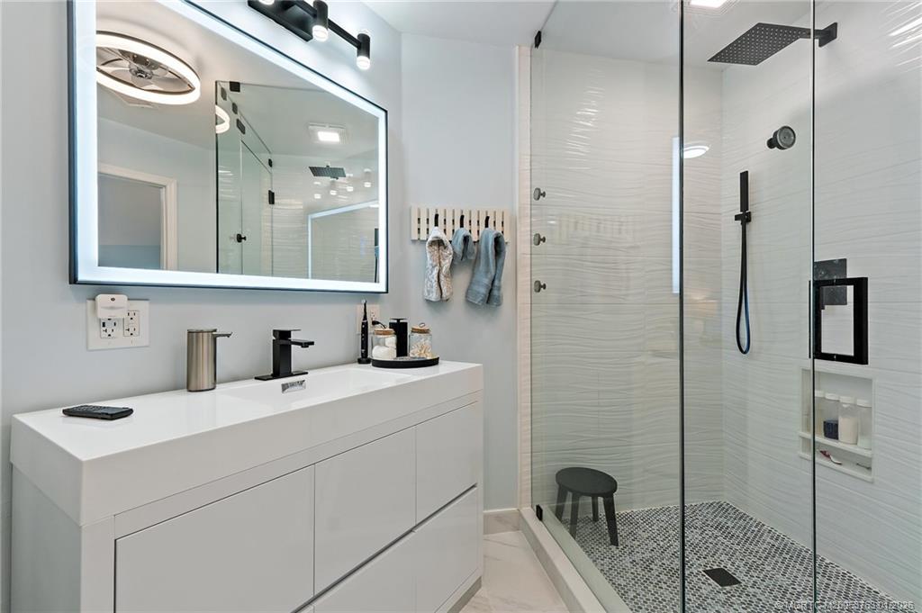 310 Southeast Denver Avenue, Unit 2 Stuart, FL 34994 - Photo 44 of 50 a bathroom with a sink a toilet a mirror and shower