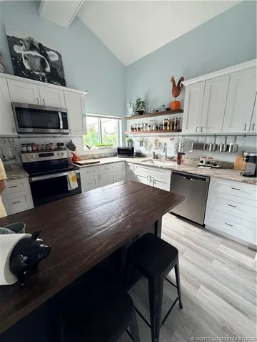 a kitchen with stainless steel appliances a stove a sink a refrigerator and cabinets