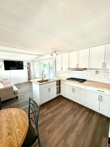 a large white kitchen with cabinets a sink and appliances