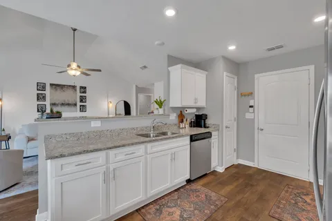 a kitchen with granite countertop a refrigerator stove and microwave