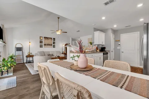 a dining table chair with granite countertop a couch and a flat screen tv