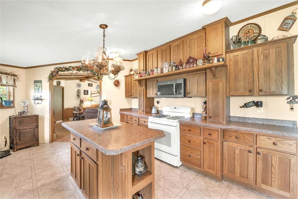 303 Wilhelm Road Rural Valley, PA 16249 - Photo 8 of 25 a kitchen with kitchen island granite countertop a sink stove and refrigerator