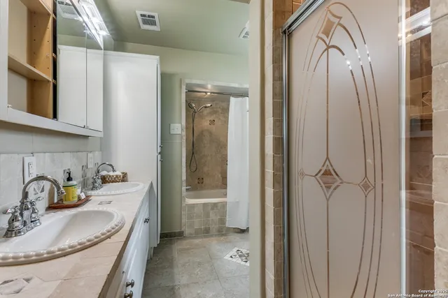 a bathroom with a granite countertop sink a mirror and shower