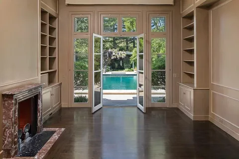 a view of empty room with wooden floor and fireplace