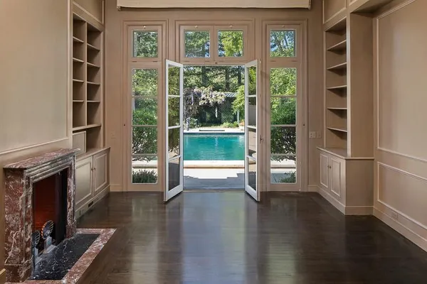a view of empty room with wooden floor and fireplace