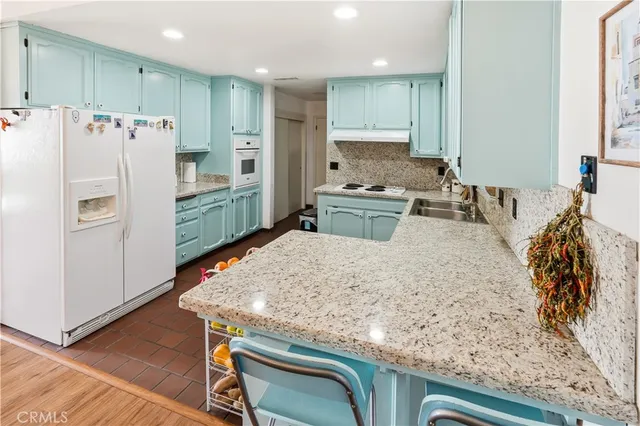 a bedroom with a bed a dresser and wooden floor