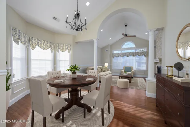 a view of an empty room with wooden floor fireplace and a window