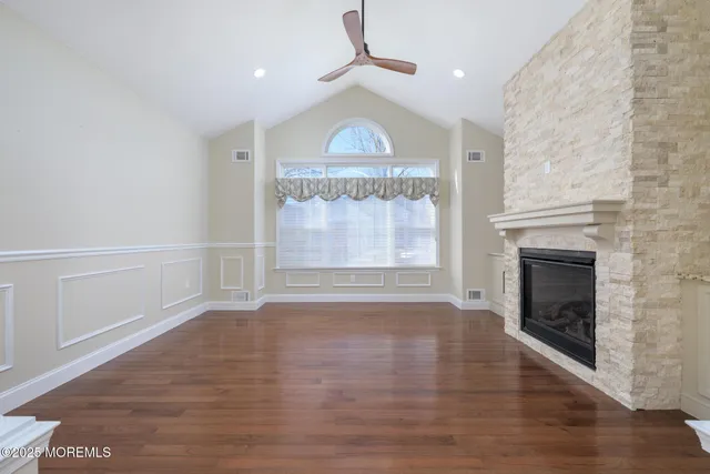 a view of empty room with wooden floor and fireplace