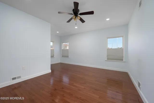 an empty room with a window and a ceiling fan
