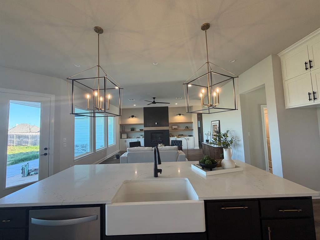 10401 T T Bury Lane Waco, TX 76708 - Photo 16 of 16 Kitchen featuring a chandelier, a ceiling fan, a kitchen island with sink, dark cabinets, and open floor plan