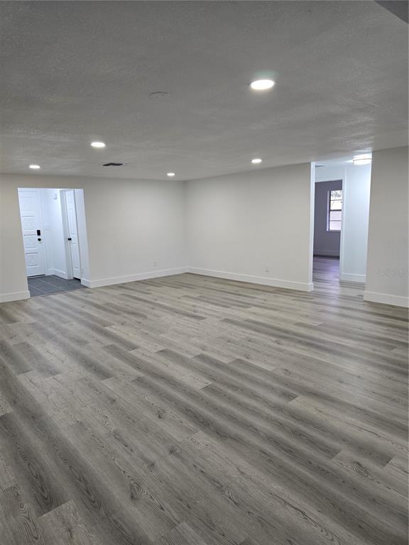 13737 Michelle Avenue Hudson, FL 34667 - Photo 11 of 25 a view of an empty room with wooden floor and windows