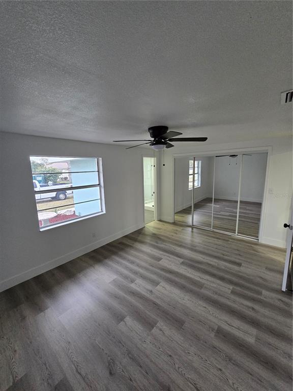 13737 Michelle Avenue Hudson, FL 34667 - Photo 15 of 25 an empty room with wooden floor and windows