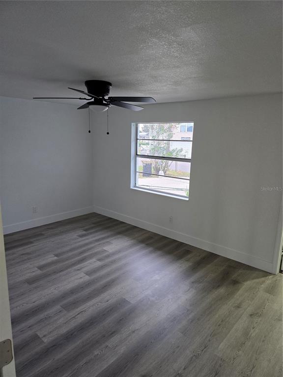 13737 Michelle Avenue Hudson, FL 34667 - Photo 17 of 25 an empty room with wooden floor and windows
