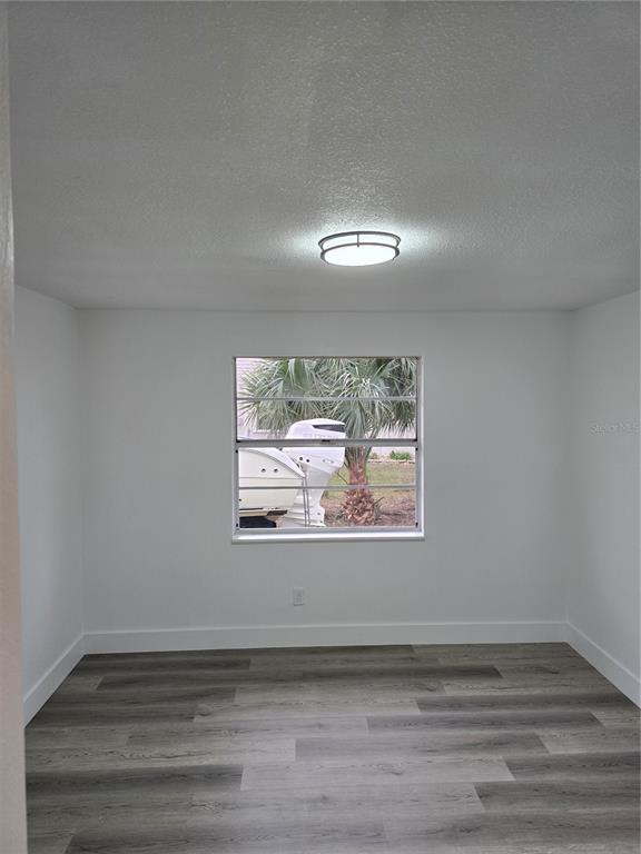 13737 Michelle Avenue Hudson, FL 34667 - Photo 18 of 25 a view of an empty room with wooden floor and a window