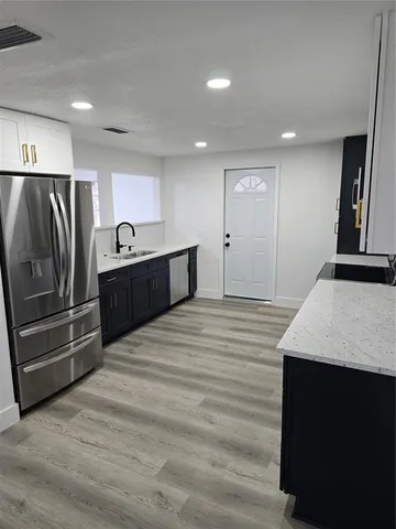 a large kitchen with kitchen island a sink stainless steel appliances and cabinets